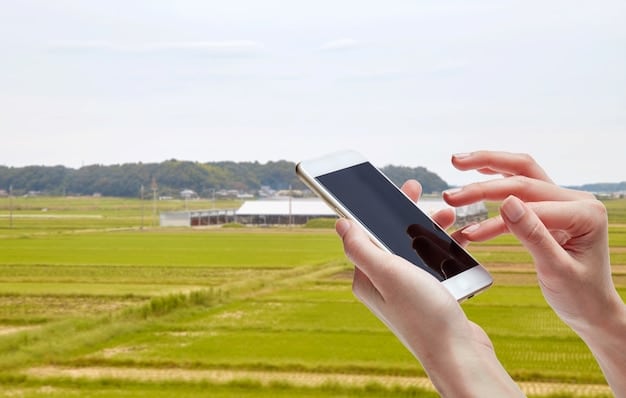 A close-up shot of a hand holding a smartphone displaying a 5G network symbol, set against a backdrop of a rural farm scene with tractors and fields.