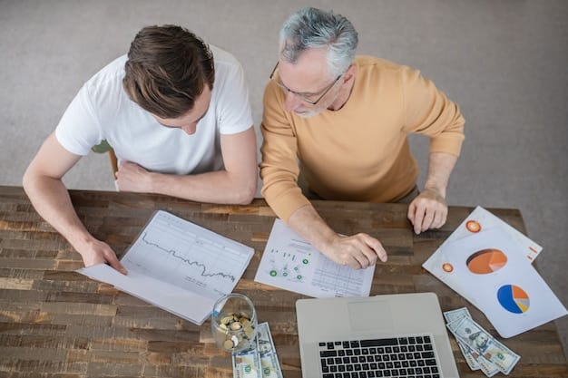 Two people sitting at a table, discussing finances and pointing at a graph that shows debt repayment progress over time.