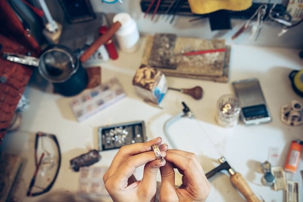 A close-up of a craftsperson's hands carefully assembling a piece of jewelry, with various tools and materials scattered around the workspace.