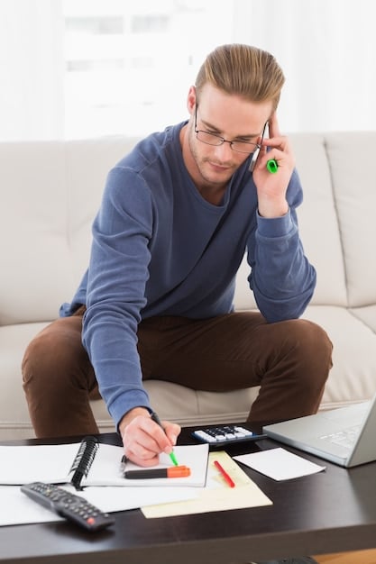 A person using a calculator with financial documents spread around, emphasizing careful calculation and planning.